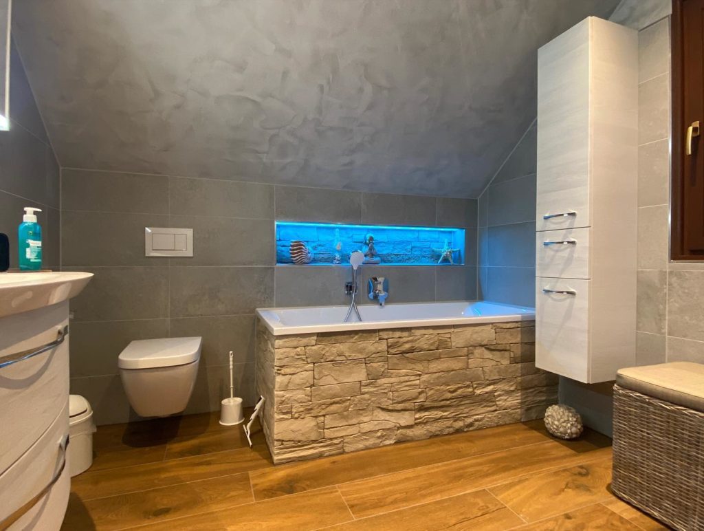 Badewanne im Badezimmer mit Holz-Stein-Mix