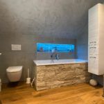 Badewanne im Badezimmer mit Holz-Stein-Mix